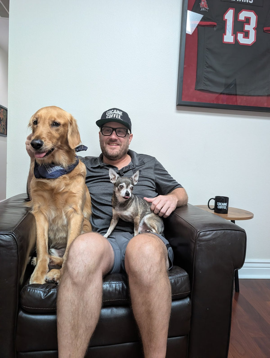 Ryan at home with his two dogs and a Cocaine Coffee mug